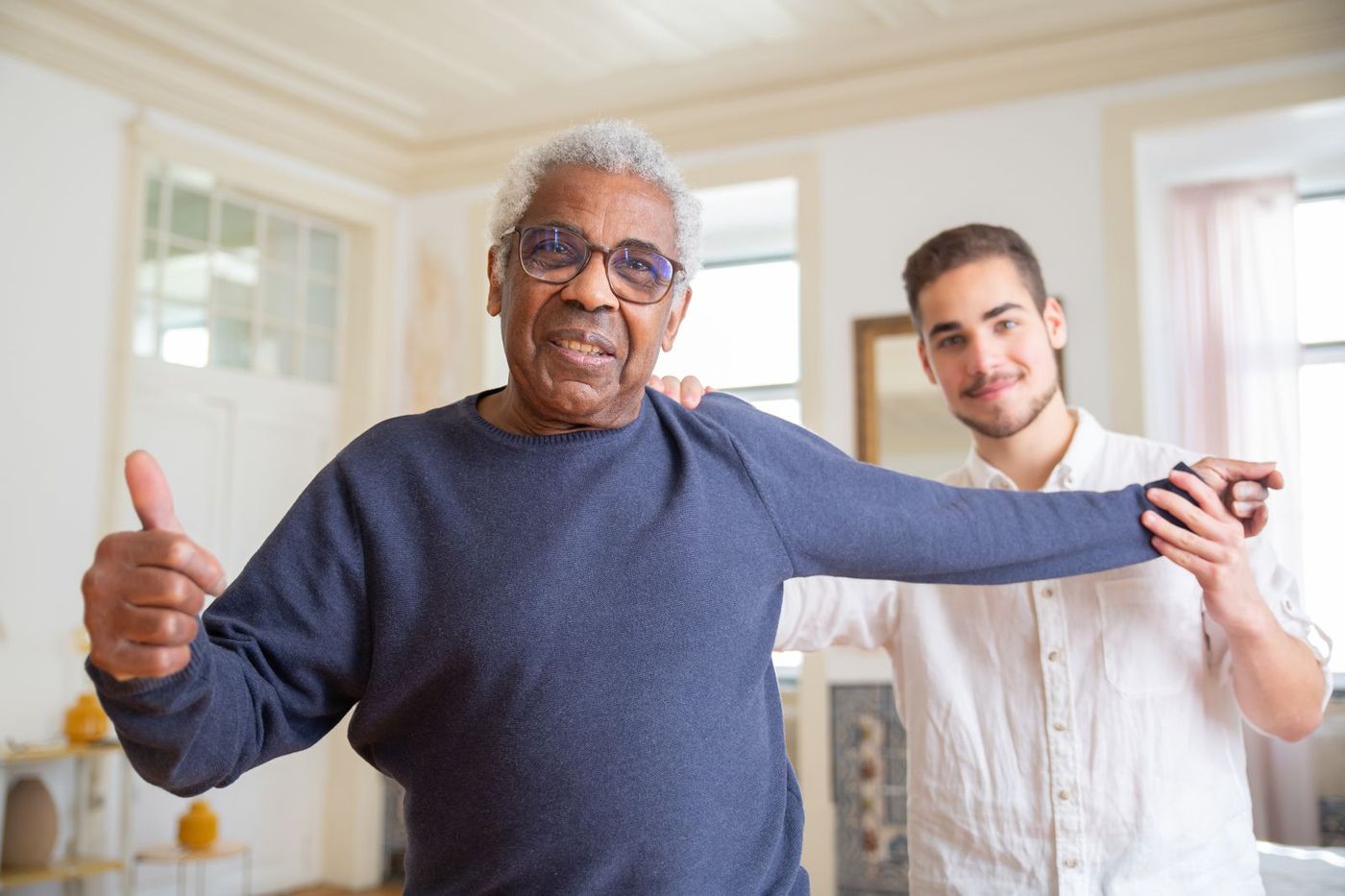 A warm home carer smiling with an older man in his living room