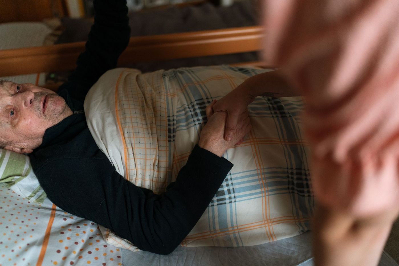A warm home carer holding hands with an older woman while arranging support at home