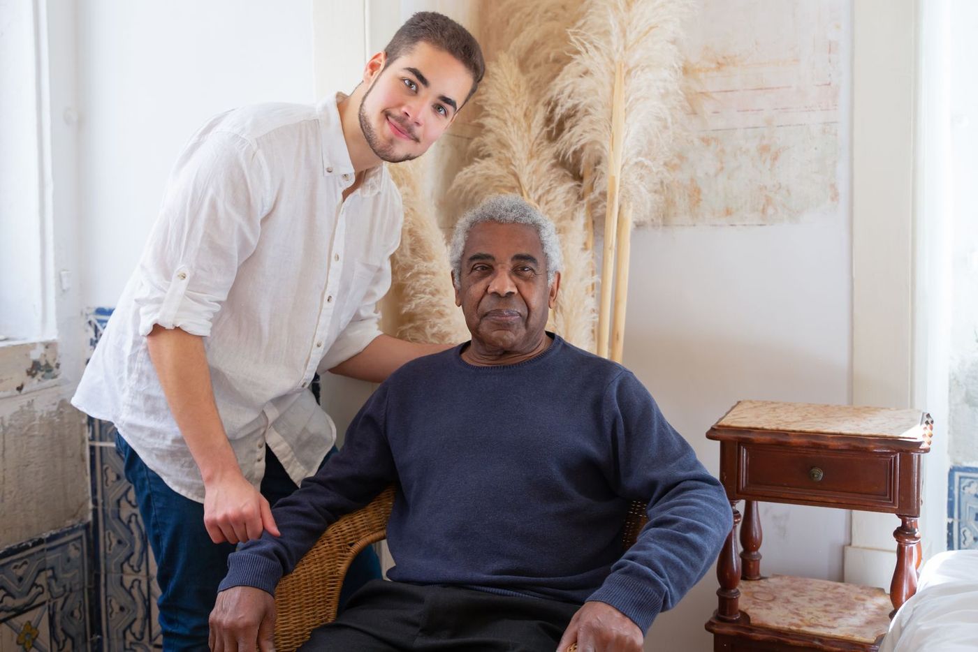 A younger man sharing a warm moment with an older man in a cosy living room